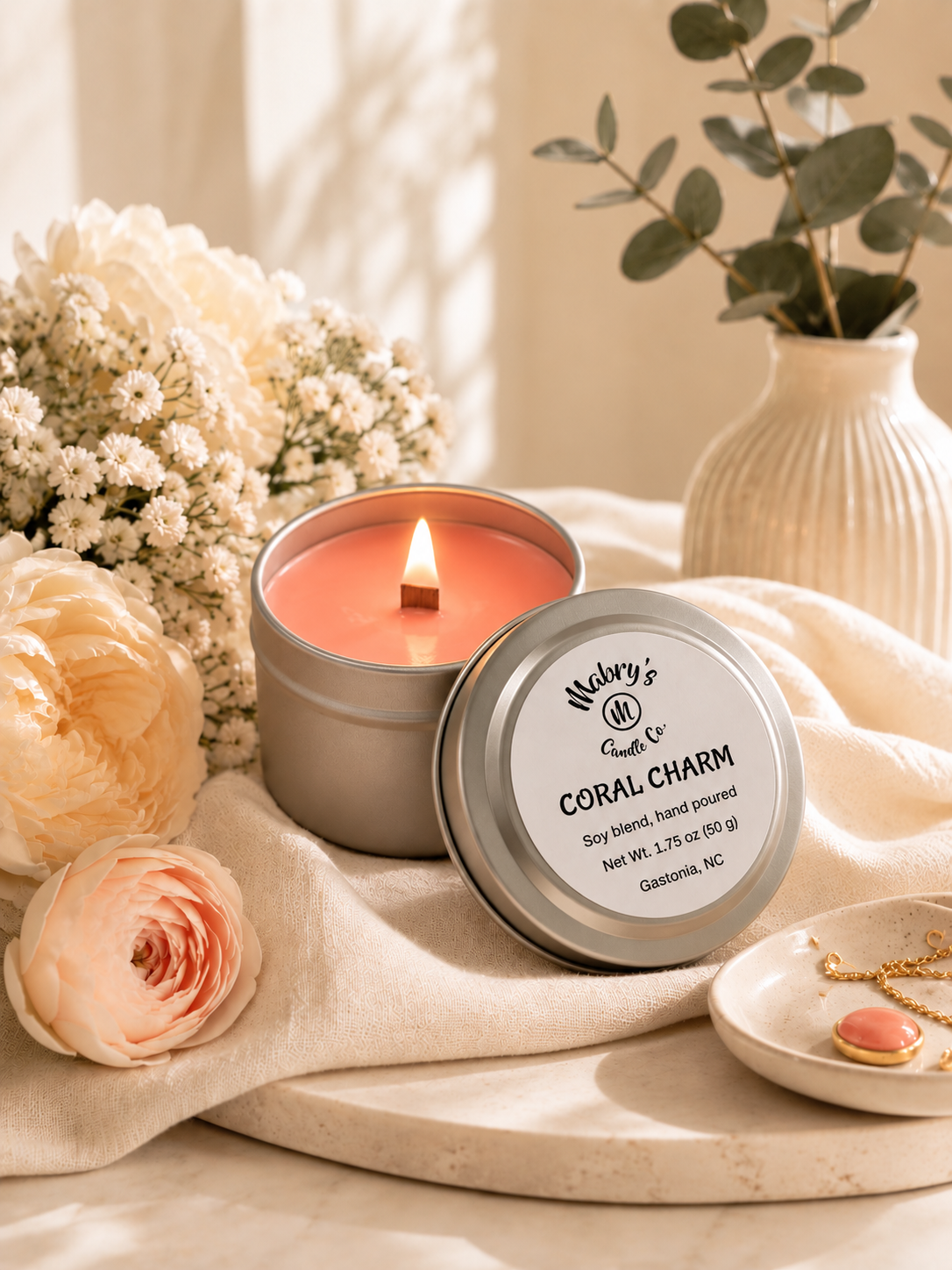 Product photo of a 2 oz candle tin in Coral Charm scent